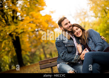 Amour et couple sur un banc dans le parc en automne Banque D'Images