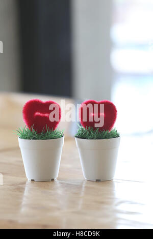 Pot de fleurs avec coeur artificiel placé sur la table dans le concept du mariage et l'amour. Banque D'Images