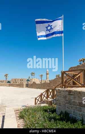 Vestiges antiques de Ceasarea et brandissant un drapeau d'Israël dans le Parc National de Césarée Maritima, Israël. Banque D'Images