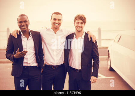 Portrait de beaux hommes posant à côté de limousine Banque D'Images