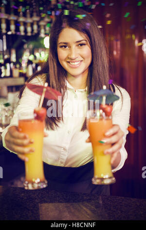 Composite image of bartender serving cocktail au comptoir du bar Banque D'Images