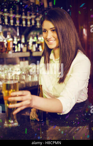 Image composite de jolie bartender serving beer Banque D'Images