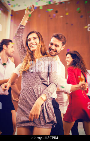 Image composite de low angle view of young friends dancing Banque D'Images