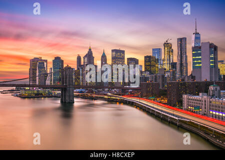 New York City financial district skyline at sunset sur l'East River. Banque D'Images