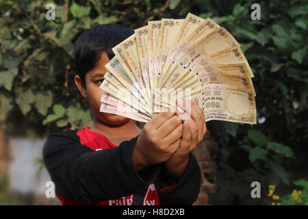 Un garçon non identifié a pris quelques monnaie indienne dans l'air. Maintenant, ces monnaies ne sont pas valides. En attente de renaissance. Banque D'Images