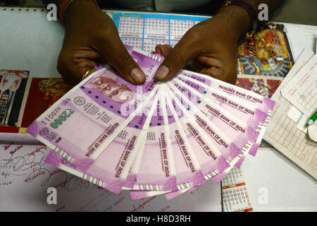 Kolkata, Inde. 10 Nov, 2016. Employé de banque montre de nouveaux 2000 Indian Rupee billets dans un United Bank of India en direction de Kolkata. Les gens de partout au pays la queue à l'extérieur des banques de tôt le matin du jeudi pour obtenir de nouveaux billets de monnaie échange de Rs.500 et Rs.1000 note que l'ont se retirer par le gouvernement de l'Union. Credit : Saikat Paul/Pacific Press/Alamy Live News Banque D'Images