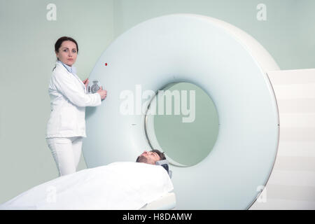 Mid adult nurse preparing patient pour CT scan test in hospital room Banque D'Images