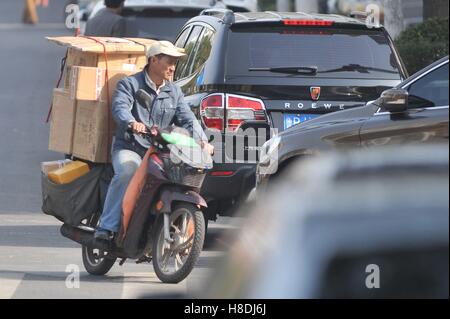 Qingdao, Qingdao, Chine. Nov 11, 2016. Qingdao, Chine-Novembre 11 2016 : (usage éditorial uniquement. La CHINE) Un livreur équitation vélo électrique chargé avec des paquets à Qingdao, province de Shandong en Chine de l'Est, Novembre 11th, 2016. Similaire à vendredi noir et le Cyber lundi aux États-Unis, Chine's Double 11 Shopping Festival est le plus grand centre commercial en ligne jour qui tombe le 11 novembre chaque année. Les statistiques montrent que le Hangzhou-basé de Alibaba a fallu qu'une heure pour atteindre le volume des ventes de 36,2 milliards de yuan le 11 novembre 2016. © SIPA Asie/ZUMA/Alamy Fil Live News Banque D'Images