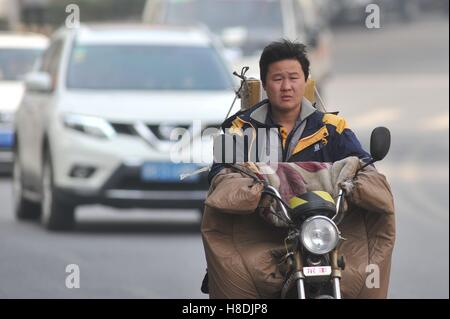 Qingdao, Qingdao, Chine. Nov 11, 2016. Qingdao, Chine-Novembre 11 2016 : (usage éditorial uniquement. La CHINE) Un livreur équitation vélo électrique chargé avec des paquets à Qingdao, province de Shandong en Chine de l'Est, Novembre 11th, 2016. Similaire à vendredi noir et le Cyber lundi aux États-Unis, Chine's Double 11 Shopping Festival est le plus grand centre commercial en ligne jour qui tombe le 11 novembre chaque année. Les statistiques montrent que le Hangzhou-basé de Alibaba a fallu qu'une heure pour atteindre le volume des ventes de 36,2 milliards de yuan le 11 novembre 2016. © SIPA Asie/ZUMA/Alamy Fil Live News Banque D'Images