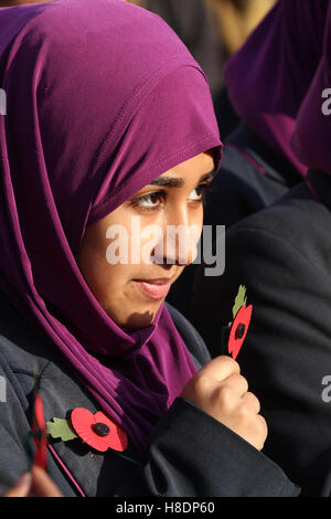 Londres, Royaume-Uni. 11 novembre, 2016. Les élèves de l'école de filles Eden , Waltham Forest posent pour des photos avec des fleurs de pavot de l'avant du silence à la place le jour du Souvenir de l'événement pour se souvenir des hommes et des femmes qui ont donné leur vie pendant les guerres le 11 novembre 2016. . Un événement organisé par la Royal British Legion inclus l'occasion d'un service, des spectacles musicaux et des lectures sur la scène à Trafalgar Square. Le premier jour de l'armistice a été tenue le 11 novembre 1919 sur les terrains du Palais de Buckingham. Crédit : David Mbiyu/Alamy Live News Banque D'Images