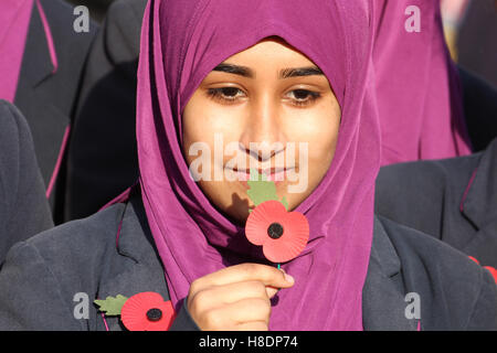 Londres, Royaume-Uni. 11 Novembre 2016 : Les élèves de l'école de filles Eden , Waltham Forest posent pour des photos avec des fleurs de pavot de l'avant du silence à la place le jour du Souvenir de l'événement pour se souvenir des hommes et des femmes qui ont donné leur vie pendant les guerres le 11 novembre 2016. . Un événement organisé par la Royal British Legion inclus l'occasion d'un service, des spectacles musicaux et des lectures sur la scène à Trafalgar Square. Le premier jour de l'armistice a été tenue le 11 novembre 1919 sur les terrains du Palais de Buckingham. Crédit : David Mbiyu/Alamy Live News Banque D'Images