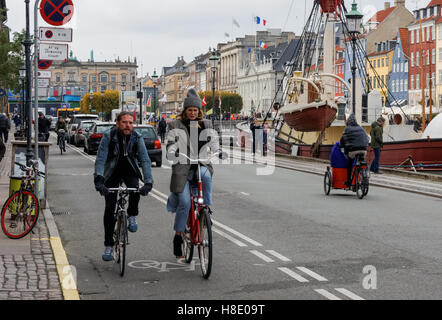 Les cyclistes le long du canal de Nyhavn à Copenhague, Danemark Banque D'Images