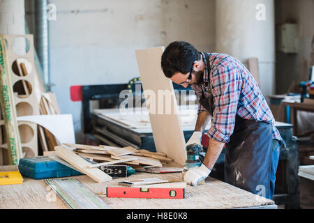 Carpenter with power grinder dans son atelier Banque D'Images