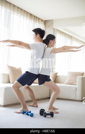 Jeune couple chinois exerçant à la maison Banque D'Images