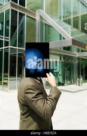 Businessman holding skull x-ray Banque D'Images