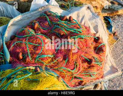 Filets de pêche multicolores sur le quai de pêche, le port de Chora à Tinos, l'une des îles des Cyclades grecques Banque D'Images