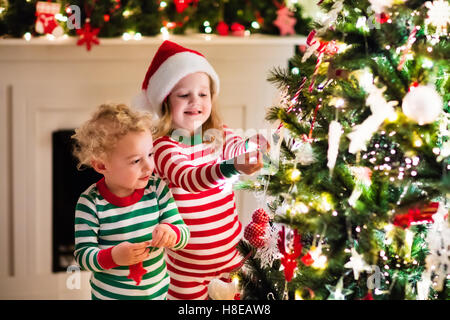 La veille de Noël de la famille au foyer. Enfants Noël ouverture des cadeaux. Les enfants de moins de Noël avec les coffrets cadeaux. Banque D'Images