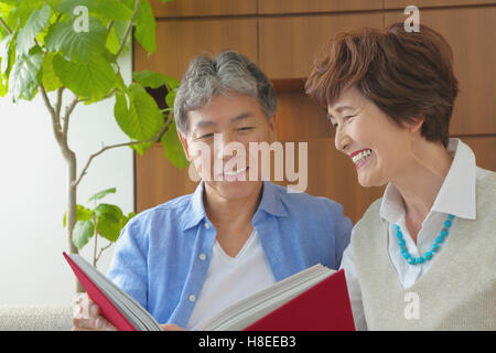 Japonais à la mode senior couple on sofa Banque D'Images