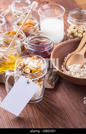 Matin sain ingrédients muesli dans verre tasse vide avec un tag pour la recette. Les flocons d'avoine, fruits secs, graines, miel, noix Banque D'Images