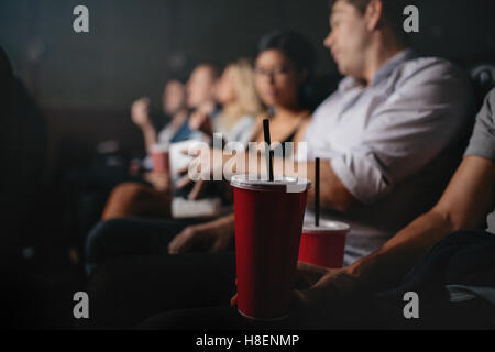 Close up de personnes avec des boissons non alcoolisées dans un cinéma, l'accent sur verre froid. Banque D'Images