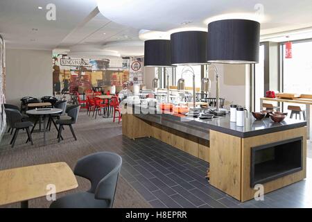 Bar à petit-déjeuner et un coin salon dans le nouvel hôtel Ibis de Cambridge, Royaume-Uni. Montre servant des plats et de la vaisselle avant de l'utiliser. Banque D'Images