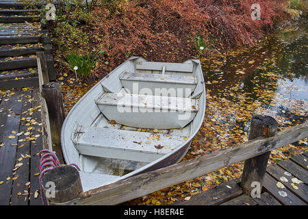 Le silence de l'automne les feuilles tombées de l'eau calme bateau ancré Banque D'Images