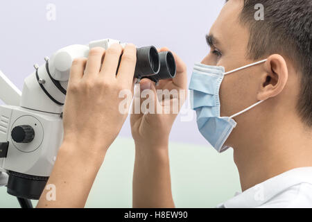 Dentiste à l'aide d'un microscope Banque D'Images