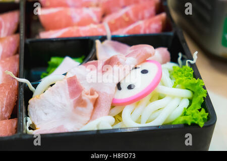 Kamaboko rose, tranches de gâteau de poissons japonais de porc, coupé en tranches et les tranches de porc porc au bacon et udon Noodle sur des plaques, pour s Banque D'Images