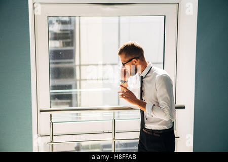 Jeune homme parlait au téléphone dans le hall de l'office Banque D'Images