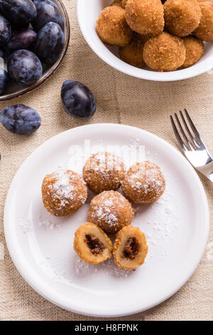 Boulettes de prune sur plaque blanche avec givrage sucre Banque D'Images