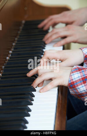 Close Up of boy playing duo de piano avec l'enseignant Banque D'Images