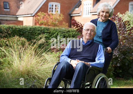 Man qui est poussé par femme en fauteuil roulant Banque D'Images