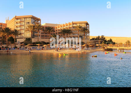 Les personnes bénéficiant de la plage avec parasols et chaises de détente dans un lieu de villégiature sur la mer Rouge à Hurghada, Egypte Banque D'Images