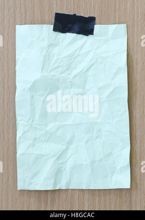 Le bloc-notes de papier froissé vert et vide de l'espace de copie sur fond de bois, vous pouvez saisir le texte du message dans l'image. Banque D'Images