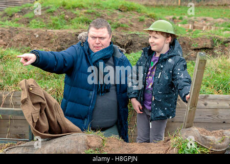 Glasgow, Ecosse, Royaume-Uni. 12 novembre, 2016. 'DIGGING IN' , avec l'aide de lettres, journaux, photographies et des manuels officiels, des tranchées WW1 reconstruit dans le parc Pollok, pour créer un centre pour l'apprentissage actif sur les droits de l'expérience des conflits et aider à explorer comment les soldats composaient dans de dangereuses et stressantes. Ici Chris Curtis de Glasgow est d'expliquer à son fils, FINN CURTIS certains des dangers et difficultés auxquels font face les soldats. Credit : Findlay/Alamy Live News Banque D'Images