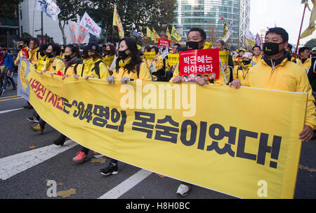 La politique de la Corée du Sud, Nov 12, 2016 : les membres de la famille de la tragédie Ferry Sewol mars pendant un rassemblement exigeant la démission du Président de la Corée du Sud Park Geun-hye à Séoul, Corée du Sud. L'étiquette lit,'Smême heures disparu était vie de 304 victimes' et un signe qu'un homme (2e R) est tenue, lit'Park Geun-hye démissionner". Les participants ont été de critiquer ce que le President Park faisait pour sept heures le 16 avril 2014, le jour de la tragédie. Plus de 1 millions de personnes ont assisté à un rassemblement aux chandelles dans le centre de Séoul le samedi pour exiger la démission du président Park, dont l'amie de longue date, Choi Banque D'Images