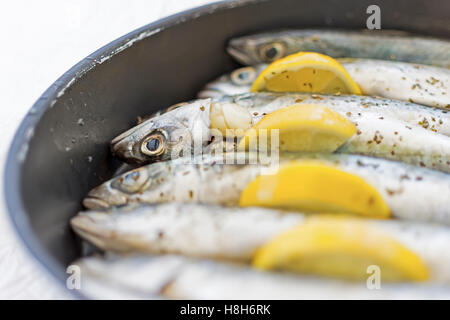 Le poisson frais dans la marinade de citrons prêt à cuire Banque D'Images