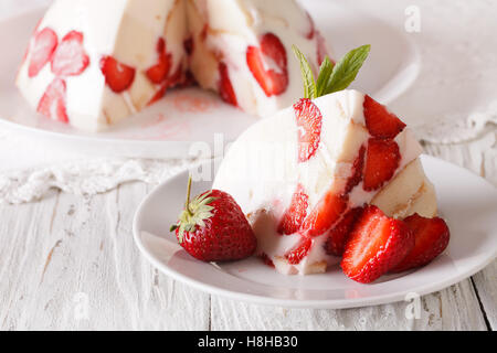 Morceau de gâteau au fromage mascarpone et fraises fraîches sur la table horizontale. Banque D'Images