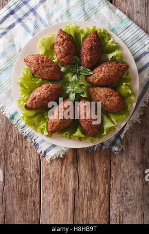 La cuisine arabe : apéritif viande kibbeh close-up sur une assiette. vertical Vue de dessus Banque D'Images