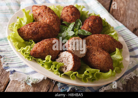 Sex kibbeh boulettes de boulgour et les noix de pin Gros plan sur une plaque horizontale. Banque D'Images