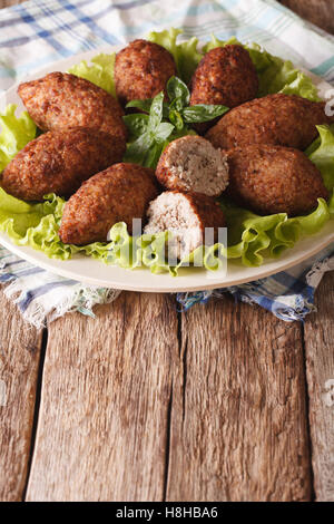 Sex kibbeh boulettes de boulgour et les noix de pin Gros plan sur une assiette. La verticale Banque D'Images