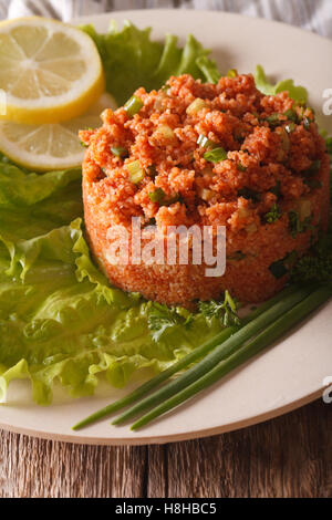 Kisir salade de boulghour turc traditionnel gros plan sur une plaque verticale sur la table. Banque D'Images