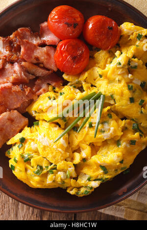 De délicieux œufs brouillés et la ciboulette, lard grillé sur une plaque verticale. close-up Vue de dessus Banque D'Images