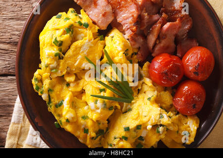 De délicieux œufs brouillés et la ciboulette, lard grillé sur une plaque horizontale. close-up Vue de dessus Banque D'Images