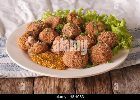 Boulettes de viande savoureuse et la moutarde Bitterballen close up sur une plaque sur la table horizontale. Banque D'Images