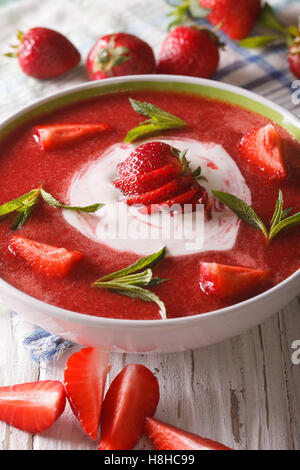 Froid doux soupe de fraises à la menthe et la crème sure dans un bol de près. La verticale Banque D'Images