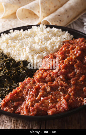 Le kifto éthiopien avec des fines herbes et fromage ayibe sur une plaque et l'injera close-up. La verticale Banque D'Images