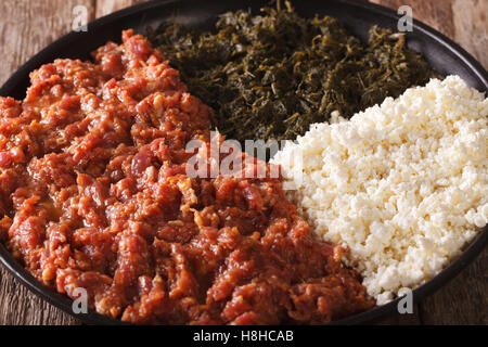 Cuisine éthiopienne : le kifto avec verts et fromage sur un ayibe macro plaque horizontale. Banque D'Images