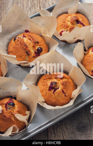 Muffins aux canneberges, les canneberges dans un bol en verre sur le vieux fond de bois ( voir ci-dessus) Banque D'Images