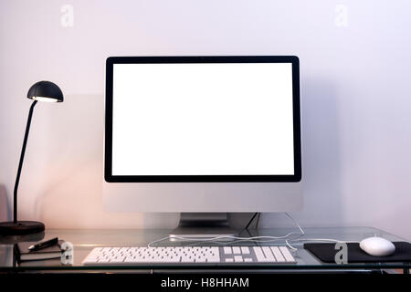 Une télévision écran ordinateur sur un bureau en verre avec écran vide Banque D'Images